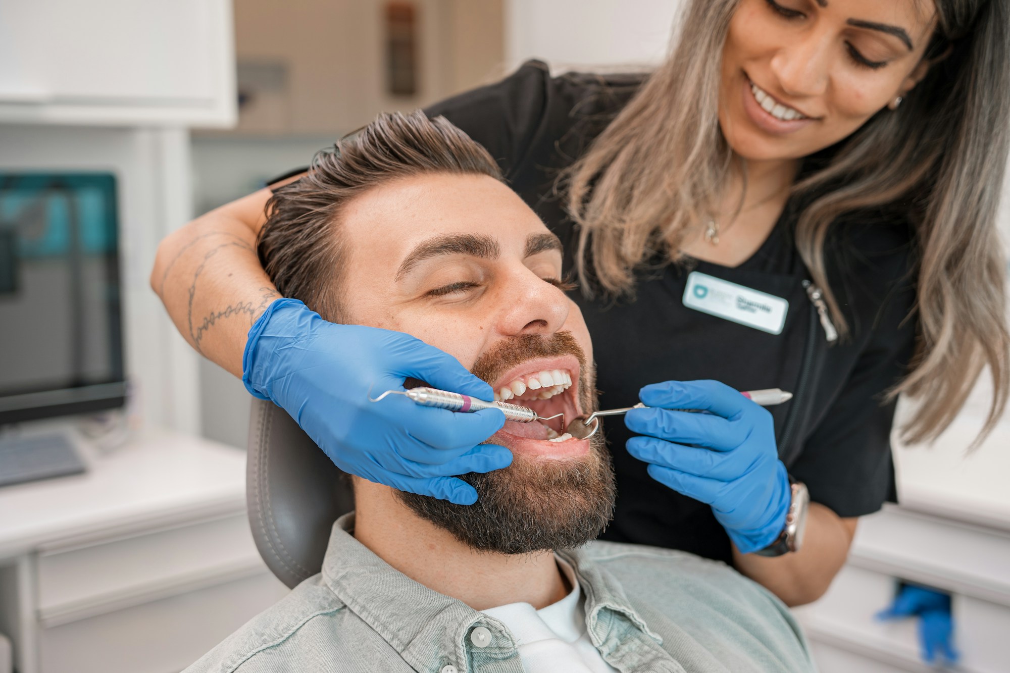 Odontóloga realizando una revisión dental a un paciente en consulta